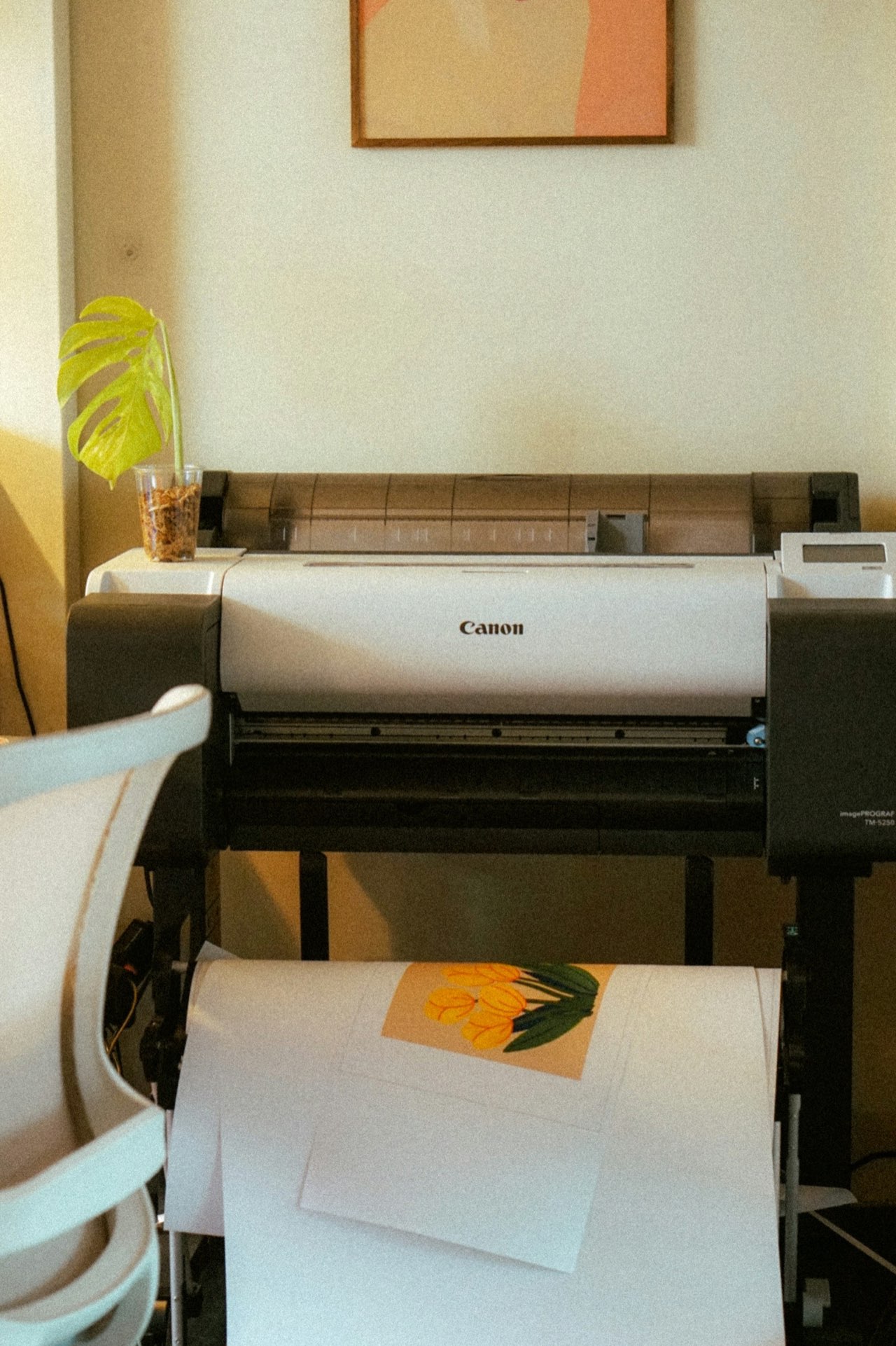 Wide-format printer producing color artwork proofs in the Merch Troop studio ahead of an event